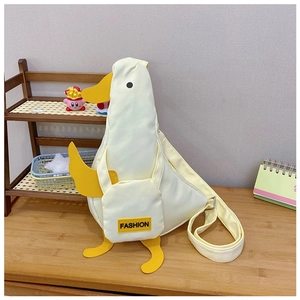 Macro detail of cute white cartoon duck canvas crossbody bag with yellow strap and accents