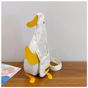 Detail of creative white duck shaped canvas crossbody bag with yellow accents and strap