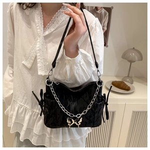 Détail du sac à bandoulière plissé noir avec chaîne argentée et pendentif papillon