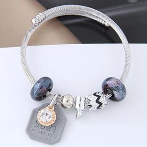 Macro shot of silver charm bracelet with galaxy glass beads and zircon pendant