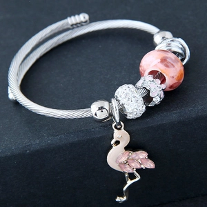 Macro detail of beaded bracelet featuring pink flamingo charm and sparkling rhinestones