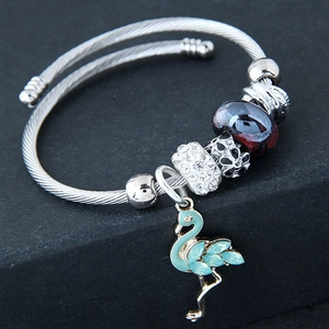 Detail of silver wire bracelet with flamingo charm and sparkling multicolored beads