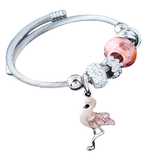 Silver twisted wire bracelet with flamingo charm and pink crystal beads on white backdrop