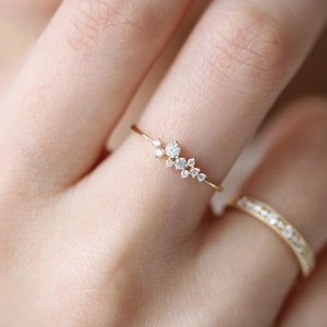 Vue macro d'une bague en or rose avec zircons en grappe et détails de pavé brillant