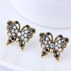 Détail macro de boucles d'oreilles papillon avec cristaux noirs et AB et finition dorée vintage