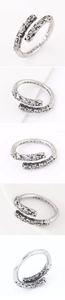 Close-up of vintage engraved scroll pattern and adjustable open ends on a silver ring
