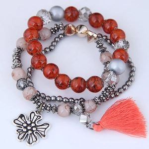 Detail view of multi-layer beaded bracelet with marble beads, cross charm and orange tassel