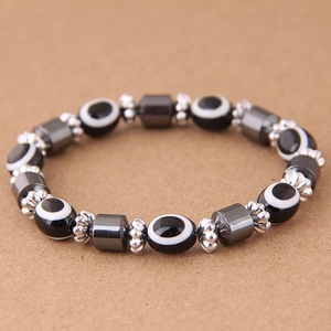 Dettaglio delle perline Evil Eye e cilindri di ematite grigia su un braccialetto