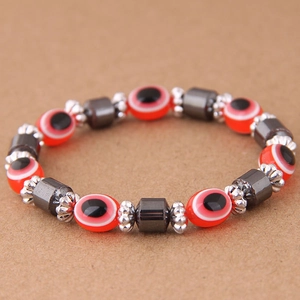 Dettaglio delle perle occhio del male rosse e pietre di ematite sul bracciale di perline