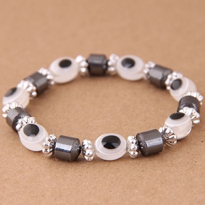 Dettaglio macro del bracciale con perline Evil Eye, ematite e distanziatori argentati