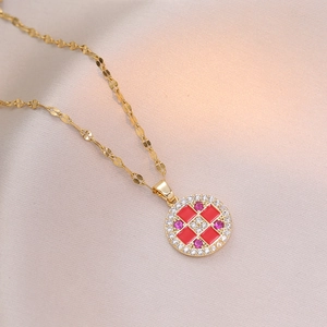 Collier doré avec pendentif quadrillé en émail rouge et cristaux sur soie beige