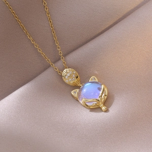 Gros plan du collier renard doré avec pierre irisée et détails en zircon sur soie