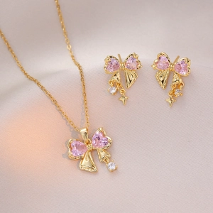 Elegant gold necklace and earrings set with pink heart crystals and bow design
