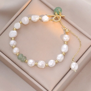 Baroque pearl bracelet with green gemstones and golden OT toggle clasp on satin