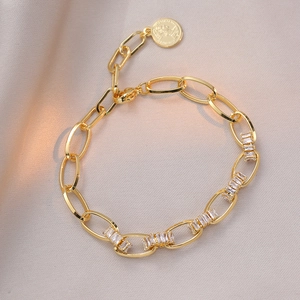 Elegant gold chain bracelet with rectangular zircon stones and a coin relief pendant