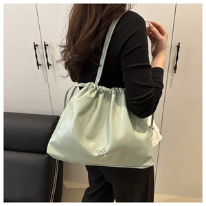 Sac seau en cuir PU vert menthe avec cordon et nœud argenté porté à l'épaule