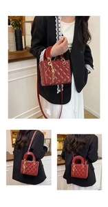 Macro shot of red quilted patent leather tote bag with gold hardware and charm