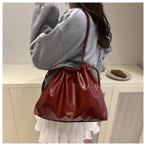 Détail du sac à cordon bordeaux avec nœud argenté et cuir plissé pour femme