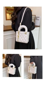 Detail of white quilted crossbody bag showing gold hardware and detachable strap