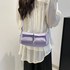 Minimalistische lavendelfarbene Nylon-Umhängetasche mit zwei Vordertaschen am Modell