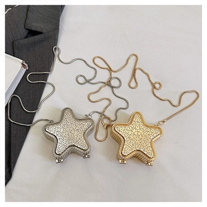 Détail de pochettes de soirée en forme d'étoile dorées et argentées avec strass et chaînes