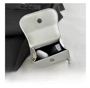 Detail showing white mini square bag interior with storage for AirPods and lipstick