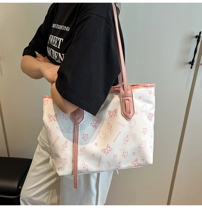 Detail of white tote bag featuring pink cartoon prints and comfortable shoulder strap