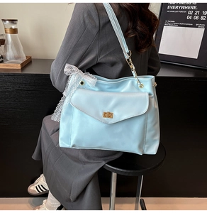 Détail d'un sac en cuir PU bleu clair avec nœud en dentelle blanche et fermoir doré