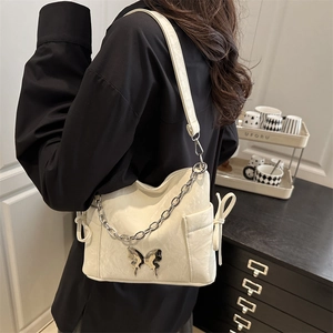 Sac bandoulière tendance blanc crème avec papillon métallique et poches à nœuds