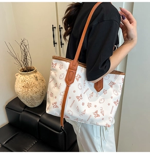Modern tote bag with bear print and brown leather handles shown in a lifestyle setting
