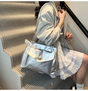 Silver shoulder bag detail with gold square lock and white lace bow decoration