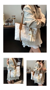 Detail of cream tote bag featuring brown cartoon prints and a cute plush bunny charm
