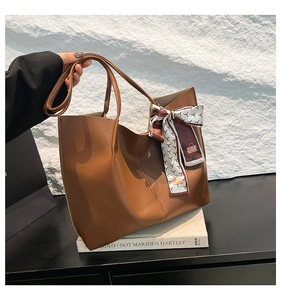 Brown leather tote bag featuring an elegant floral silk scarf and large capacity interior