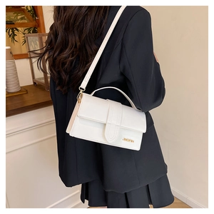 Détail d'un sac à bandoulière en cuir PU blanc avec logo doré JINGPIN porté par un modèle