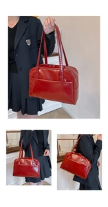 Detail view of large red patent leather shoulder bag with glossy finish and dual zippers