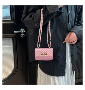 Close-up of pink quilted mini crossbody bag with gold chain strap and turn-lock
