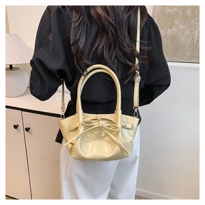 Detail of cream yellow leather handbag with bow decoration and adjustable shoulder strap
