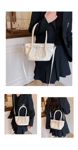 Detail of cream glossy handbag with bow accent and detachable strap for versatile styling
