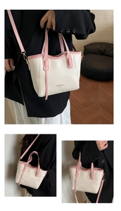Detail view of cream and pink tote bag with gold hardware and adjustable strap options