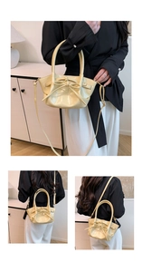 Detail of a creamy yellow glossy handbag featuring a bow ornament and adjustable strap