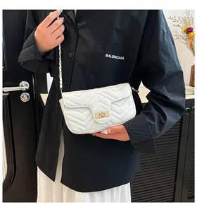 Quilted white crossbody bag with gold lock shown on model for size and style reference