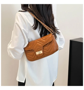 Detailed back view of a caramel quilted crossbody bag with gold chain and turn-lock