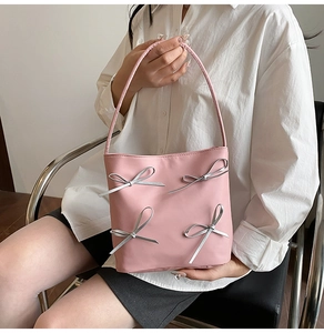Detail der rosa Bucket Bag mit silbernen Schleifenakzenten und glattem Leder