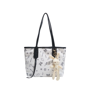 White minimalist tote bag with artistic black doodle prints and a plush bunny charm