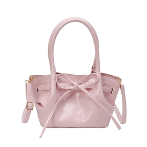 Pink minimalist bucket bag with decorative bow and detachable crossbody strap