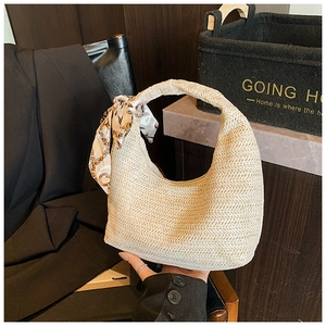 Detailansicht der cremefarbenen Stroh-Hobo-Tasche mit dekorativem bedrucktem Seidentuch am Griff