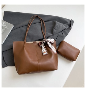 Brown tote bag detail with small pouch, stitching and silk scarf accessory