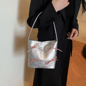 Silver metallic bucket bag for women with pink ribbon bows on black blazer outfit