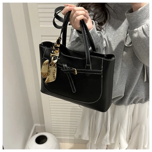 Détail du sac cabas noir avec coutures contrastées blanches et foulard en soie décoratif