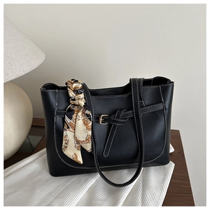 Détail du sac cabas noir avec surpiqûres blanches et foulard en soie sur la poignée